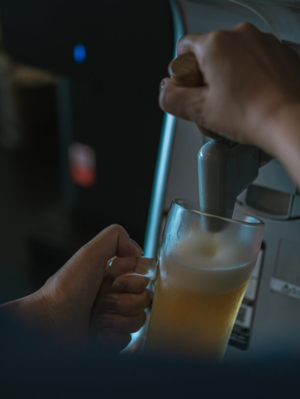 サーバーでジョッキにビールを注いでいる様子